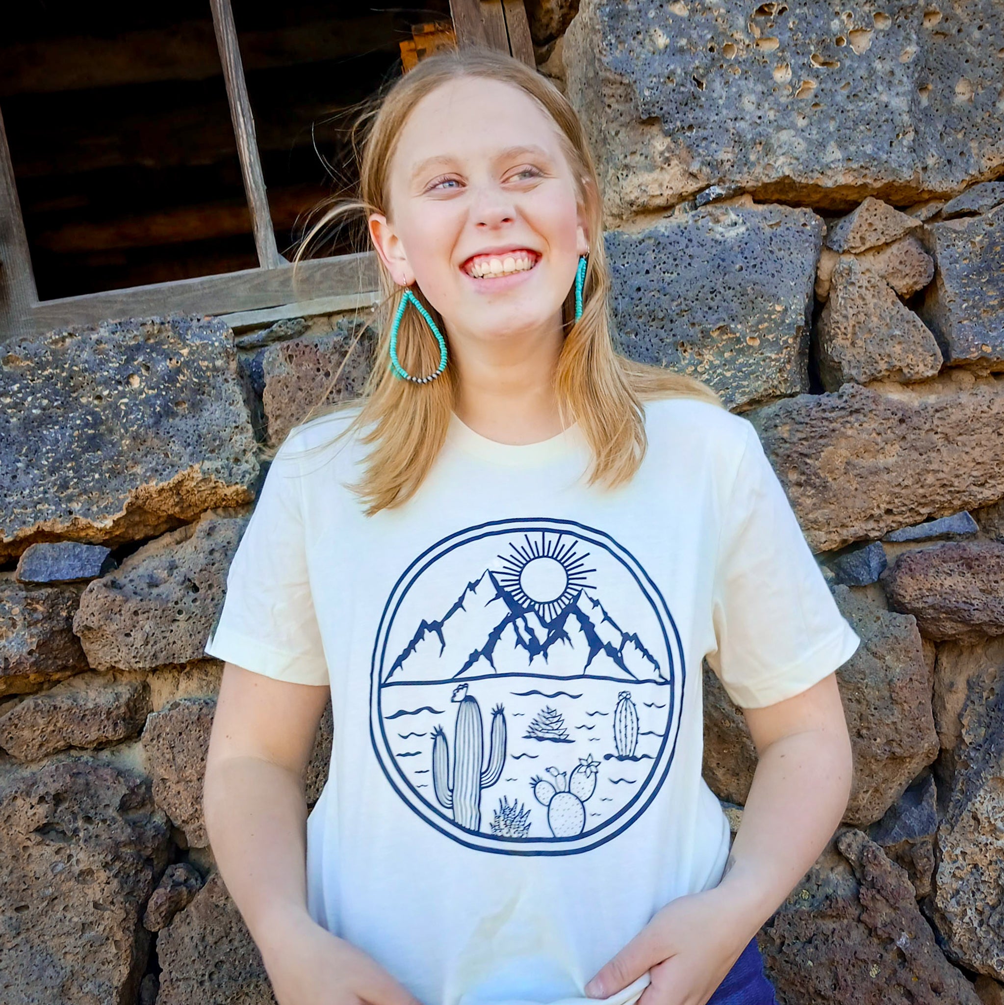 Girl wearing a Western cactus desert tee with Arizona vibes with a rock walk in the background