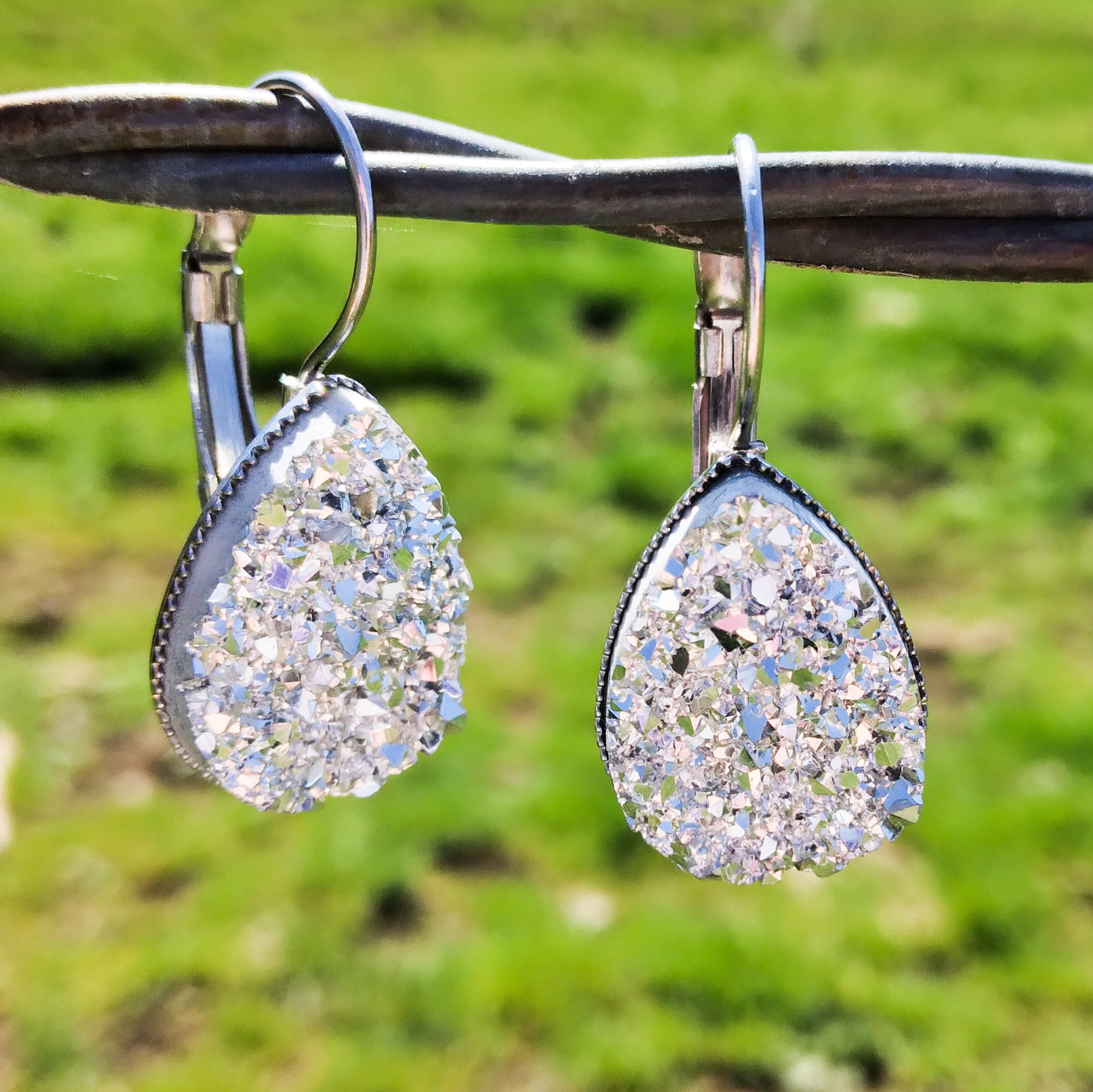 Snow teardrop dangles displayed on a wire outside.